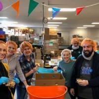 Alumni sort food into boxes at Kids' Food Basket